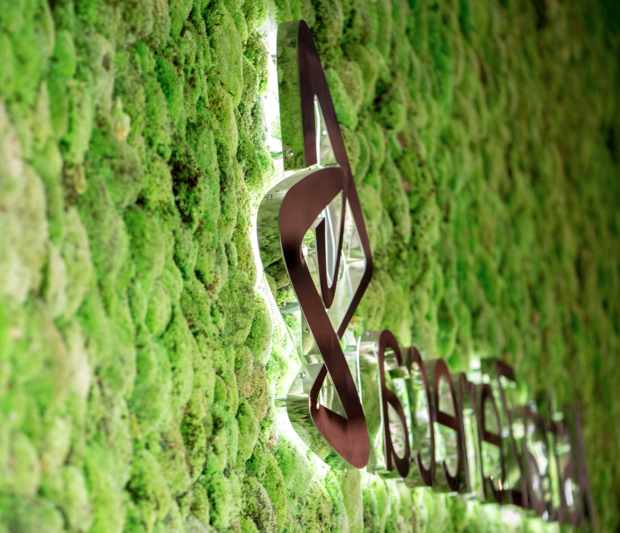AstraZeneca logo on a living wall designed like a forest